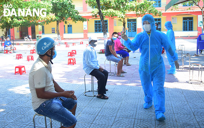 Nhân viên y tế phường Nại Hiên Đông (quận Sơn Trà) tham gia lấy mẫu xét nghiệm SARS-CoV-2 tại cộng đồng. (Ảnh chụp sáng 3-9) Ảnh: TRỌNG HUY