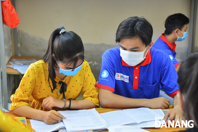A volunteer helping a Co Tu pupils at the Pham Phu Thu Senior High Boarding School review her lesson prior to the exams