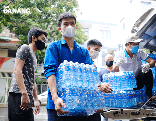 Một nhóm thiện nguyện hỗ trợ nước uống cho sinh viên Trường Đại học Sư phạm kỹ thuật (Đại học Đà Nẵng) gặp khó khăn do Covid-19 trong những ngày tháng 8. Ảnh: TẤN LỰC
