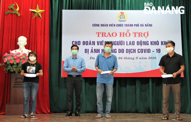 Phó Chủ tịch Liên đoàn Lao động thành phố Hoàng Hữu Nghị (thứ 2, trái sang) trao hỗ trợ cho đoàn viên đặc biệt khó khăn. Ảnh: L.P