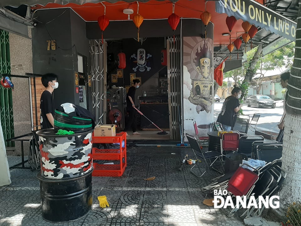 Ngay trong sáng 5-9, nhiều hàng quán bắt đầu mở cửa dọn dẹp để mở cửa kinh doanh trở lại với hình thức bán mang đi, bán hàng qua online ( ảnh chụp trưa 5-9 tại quán cafe S.M.L đường Nguyễn Du). Ảnh: KHÁNH HÒA