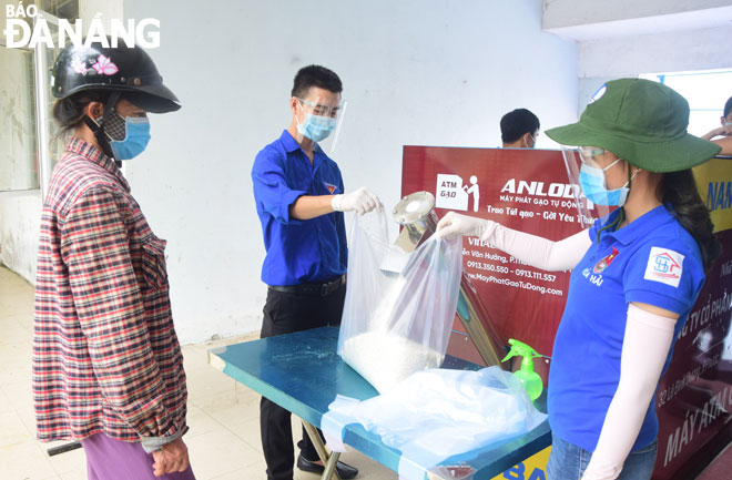 Bà Huỳnh Thị Quyết (bìa trái), tổ 47,  phường Hòa Hải, đến nhận gạo hỗ trợ từ chương trình “ATM gạo” do Quận Đoàn Ngũ Hành Sơn tổ chức.Ảnh: T.H