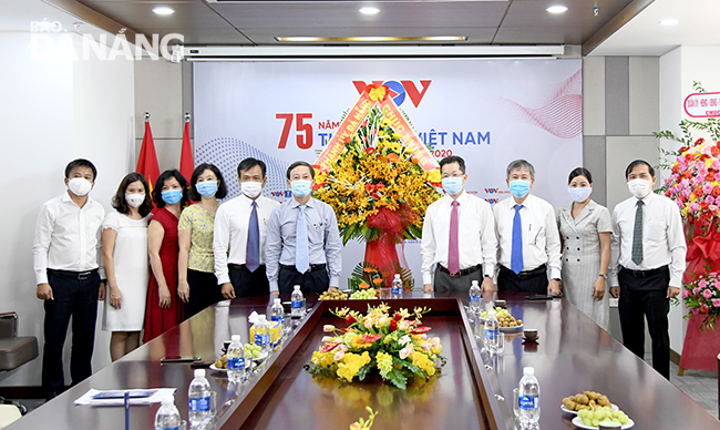 Phó Bí thư Thường trực Thành ủy Nguyễn Văn Quảng (thứ 4 từ phải sang) tặng hoa chúc mừng cán bộ, nhân viên, những người làm báo ở VOV. Ảnh: ĐẶNG NỞ