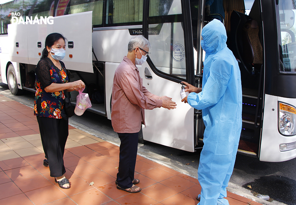 Công dân tỉnh Bắc Ninh sát khuẩn tay trước khi lên xe trở về địa phương.