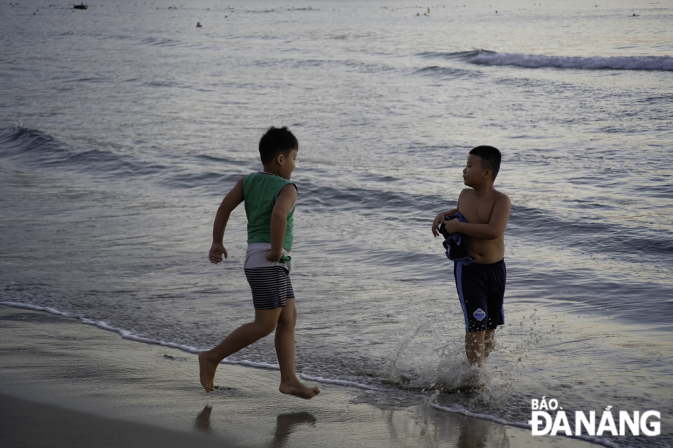 Những em nhỏ hào hứng vui chơi dưới ánh bình minh trên biển Đà Nẵng. Ảnh: NGUYỄN LỄ