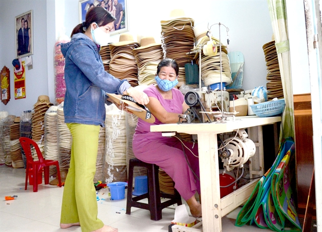 A single mother Cái Thị Mỹ Hiệp (right) makes sedge hats. She set up a hat-making workshop, offering jobs for 17 other women in Hoà Phát Ward, Cẩm Lệ District, Đà Nẵng City.