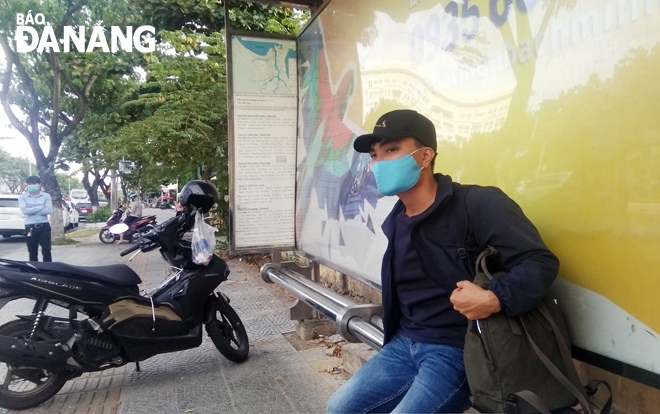 Anh Nguyễn Lê Huy Thành đợi xe buýt về quê sau 1 tháng “cách ly” vì dịch bệnh.  Ảnh: X.S