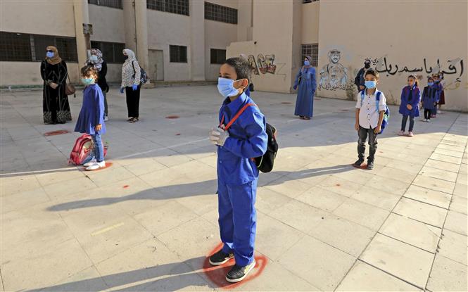  Học sinh thực hiện giãn cách nhằm phòng dịch COVID-19 trong ngày đầu tiên tựu trường ở Amman, Jordan ngày 1/9/2020. Ảnh: AFP/TTXVN