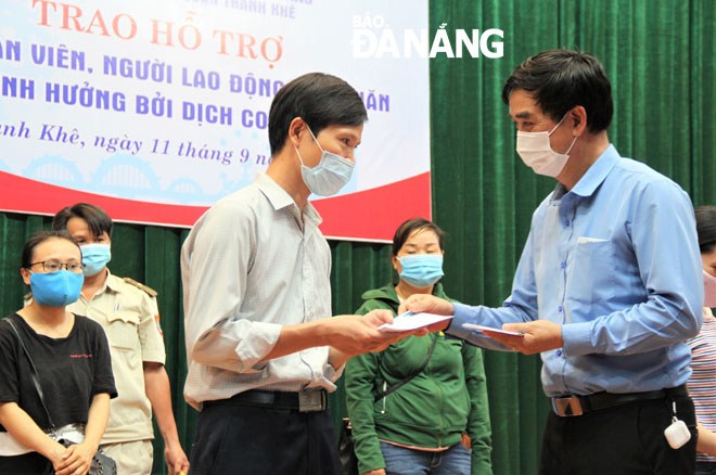 Vice Chairman of the Da Nang Labour Union Hoang Huu Nghi (right) presenting cash gifts to poor members