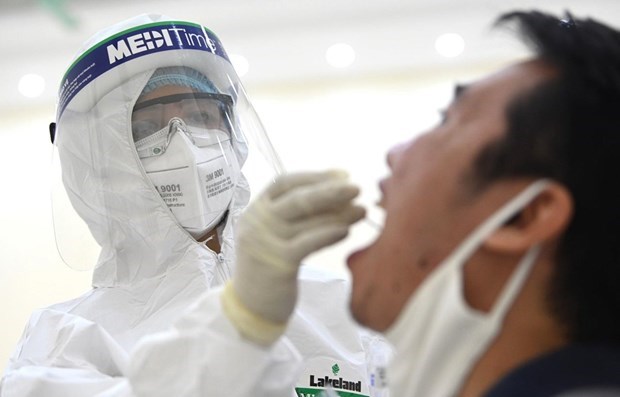 A health worker takes a sample for SARS-CoV-2 testing (Photo: VNA)
