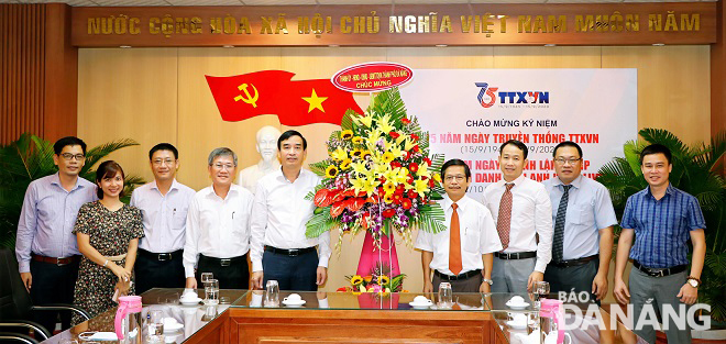 Phó Chủ tịch UBND thành phố Lê Trung Chinh (giữa) tặng hoa chúc mừng Cơ quan TTXVN khu vực miền Trung - Tây Nguyên. Ảnh: L.P