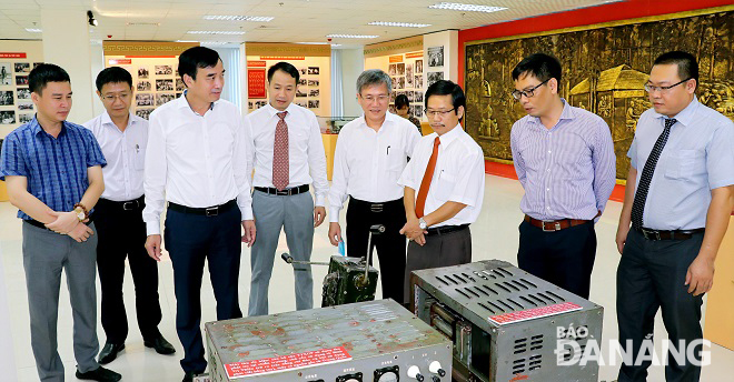 Phó Chủ tịch UBND thành phố Lê Trung Chinh (thứ 3, trái sang) thăm phòng truyền thống của Cơ quan TTXVN khu vực miền Trung - Tây Nguyên. Ảnh: L.P