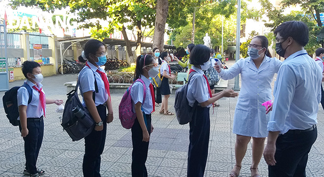 Nguyen Hue Junior High School pupils had their temperatures checked before entering classrooms