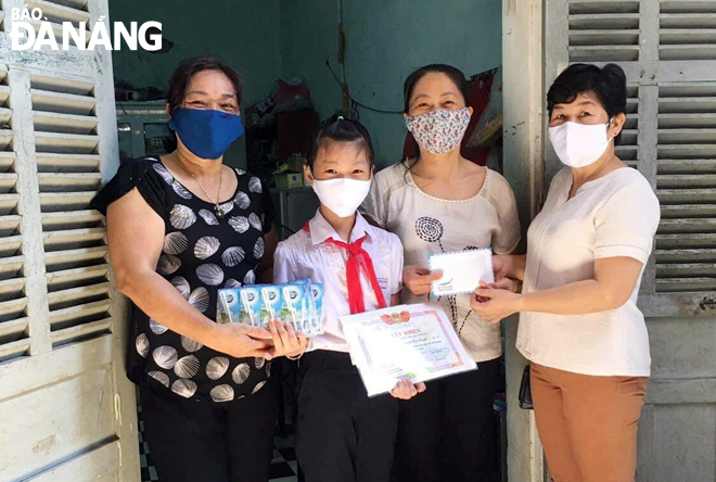 Representatives from Hai Chau District’s Hai Chau 1 Ward chapter of the Da Nang Women Union (left and right) presenting cash and in-kind gifts to Mrs Nguyen Thi Lan Huong and her daughter (centre)