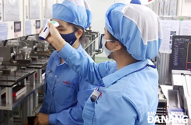 Các doanh nghiệp bảo đảm sản xuất và an toàn cho người lao động. Trong ảnh: Đo thân nhiệt của người lao động tại Công ty TNHH Điện tử Việt Hoa. Ảnh: MAI QUẾ	