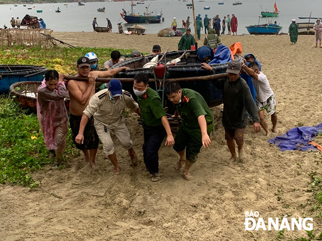 Công an thành phố đã triển khai lực lượng xuống địa bàn giúp ngư dân quận Sơn Trà kéo tàu thuyền lên bờ để tránh bão số 5. Ảnh: NAM PHƯƠNG