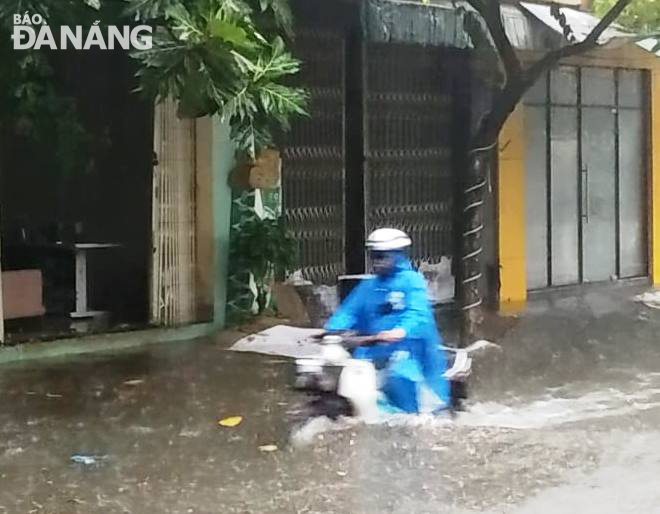 A road user managing to go through a flooded street