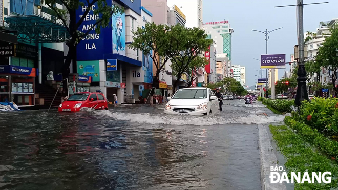 Vehicles submerged under water along a section of Nguyen Van Linh Street