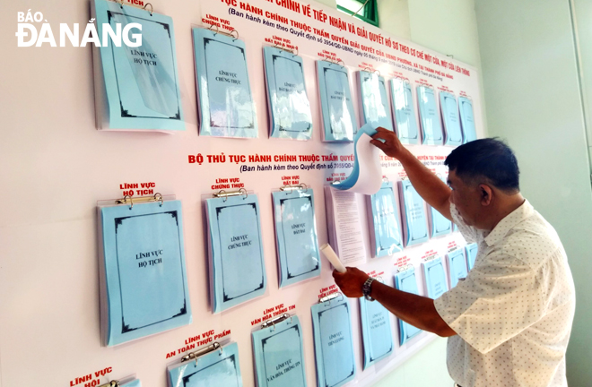 A local resident learning about the list of local administrative procedures in a residential area, Hoa Cuong Nam Ward, Hai Chau District