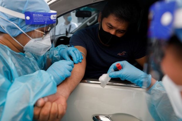 A healthcare worker takes blood sample from a passenger in Manila (Source: Reuters)