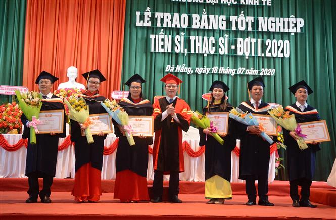 Đại diện trường Đại học Kinh tế (Đại học Đà Nẵng) tặng giấy khen cho các tân Thạc sĩ có thành thành tích xuất sắc trong học tập, nghiên cứu. Ảnh: Văn Dũng/TTXVN