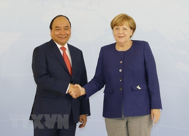 Prime Minister Nguyen Xuan Phuc (L) shakes hands with German Chancellor Angela Merkel (Photo: VNA)