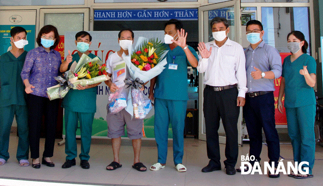 Bệnh nhân Covid-19 cuối cùng ở Đà Nẵng (thứ 5, phải sang) xuất viện trong sáng 23-9 tại Bệnh viện dã chiến Hòa Vang. 		              Ảnh: XUÂN DŨNG