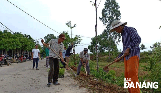 Người dân dọn vệ sinh trên đường liên thôn Nhơn Thọ 1 - Tân Hạnh (xã Hòa Phước). 						              Ảnh: LÊ VĂN THƠM