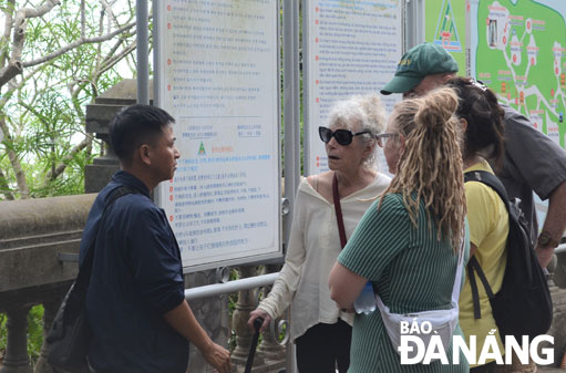 A picture taken in December 2019 showing an international tour guide (left) guiding tourists at the Marble Mountains tourist area