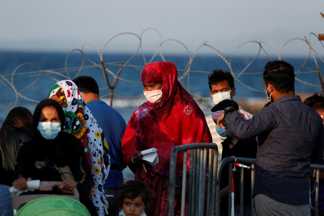 Những người nhập cư chờ đợi để vào một cơ sở tị nạn tạm thời ở đảo Lesbos của Hy Lạp sau vụ hỏa hoạn tại trại tị nạn Moria hồi tháng 9-2019. Ảnh: Reuters