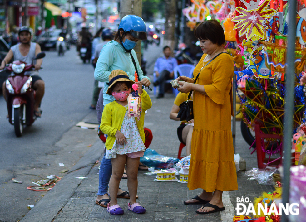 A kid expressing her joy as her mother buys an animal-shaped plastic lantern to her