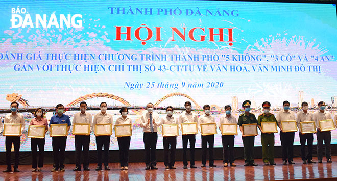 Municipal Party Committee Secretary Truong Quang Nghia (7th left) and honourees in the ‘5 No’s’ programme during the 2000-2020 period