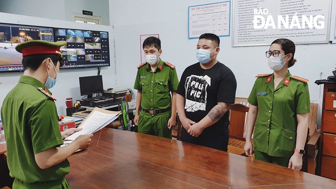 Cơ quan Cảnh sát điều tra Công an quận Sơn Trà đọc lệnh khởi tố, bắt tạm giam Nguyễn Tiến Dũng. Ảnh: P.C