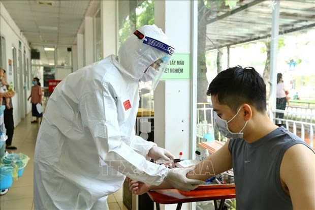A health worker takes a blood sample for SARS-CoV-2 testing at Hà Nội's Thanh Nhàn Hospital.