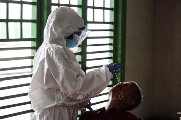 A health worker in Indonesia takes patient's sample for COVID-19 testing (Photo: VNA)