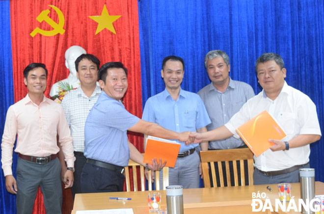 Lãnh đạo Công ty CP Môi trường đô thị Đà Nẵng (bìa phải) ký kết hợp tác với các ngân hàng để chuyển đổi hình thức thu tiền rác qua thanh toán không tiền mặt. Ảnh: HOÀNG HIỆP