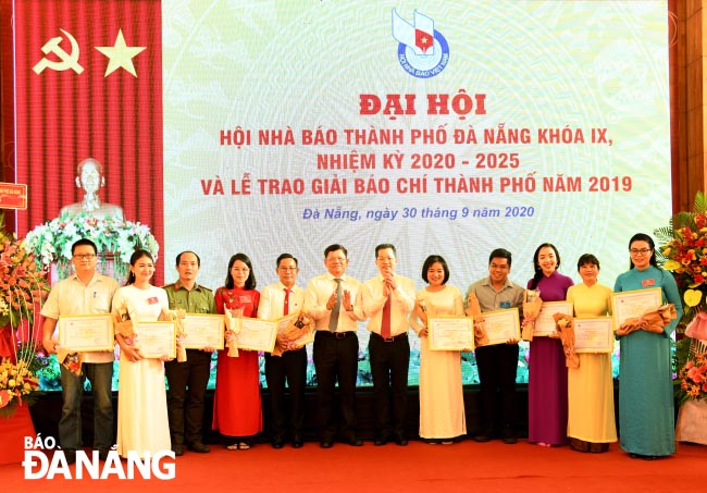 Phó Bí thư Thường trực Thành ủy Nguyễn Văn Quảng trao giải nhất Giải báo chí thành phố năm 2019 cho các tác giải đạt giải. Ảnh: ĐẶNG NỞ