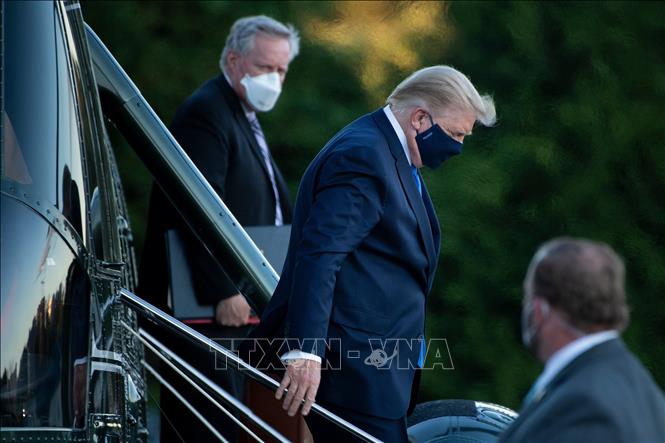 Tổng thống Mỹ Donald Trump (giữa) rời khỏi chuyên cơ khi tới Trung tâm quân y Walter Reed ở Bethesda, bang Maryland ngày 2/10. Ảnh: AFP/TTXVN