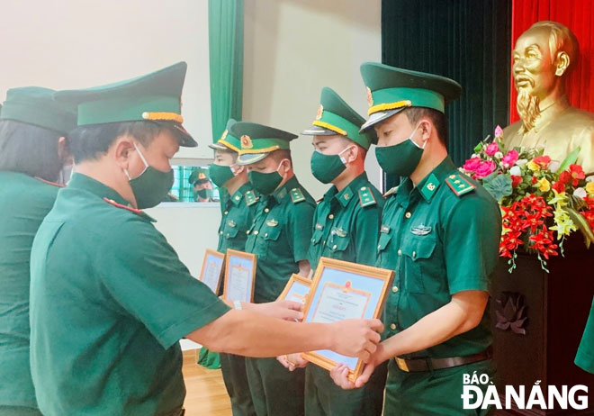 Đại tá Đỗ Văn Đông (trái), Bí thư Đảng ủy, Chính ủy Bộ đội Biên phòng thành phố trao thưởng cho cán bộ, chiến sĩ thực hiện tốt nhiệm vụ phòng, chống Covid-19 vừa qua.  Ảnh: Hoàng Quỳnh