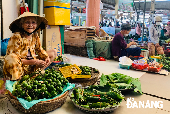 An elderly woman selling fresh areca nuts and betel leaves in the Tuy Loan Market