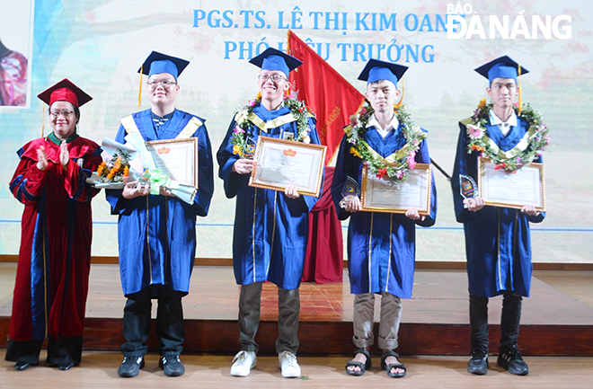 PGS.TS Lê Thị Kim Oanh (bên trái), Phó Hiệu trưởng Trường Đại học Bách khoa tặng giấy khen cho các cử nhân có thành tích học tập và rèn luyện xuất sắc Ảnh: NGỌC PHÚ
