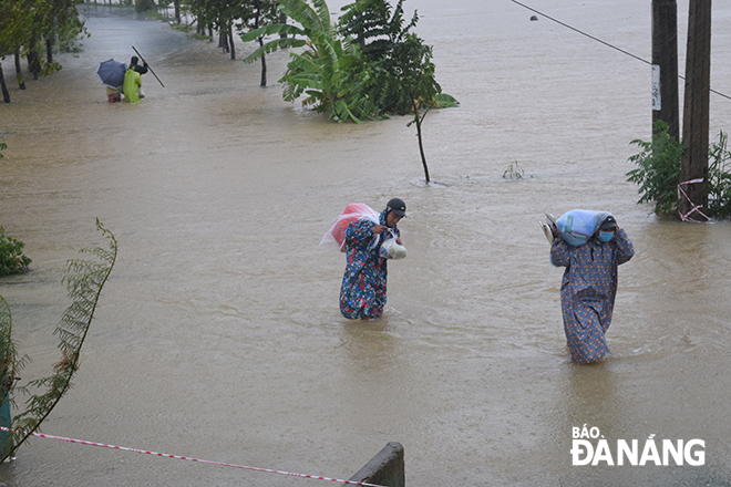 Tuyến đường dẫn vào thôn Tây An, xã Hòa Châu đang bị nước lũ tràn qua và dâng lên. Ảnh: HOÀNG HIỆP