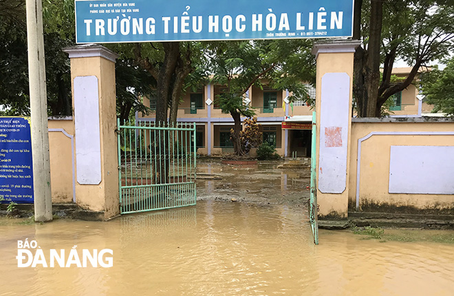 Đến trưa 12-10, nước lũ vẫn còn ứ đọng tại sân trường tiểu học Hòa Liên điểm Trường Trường Định.