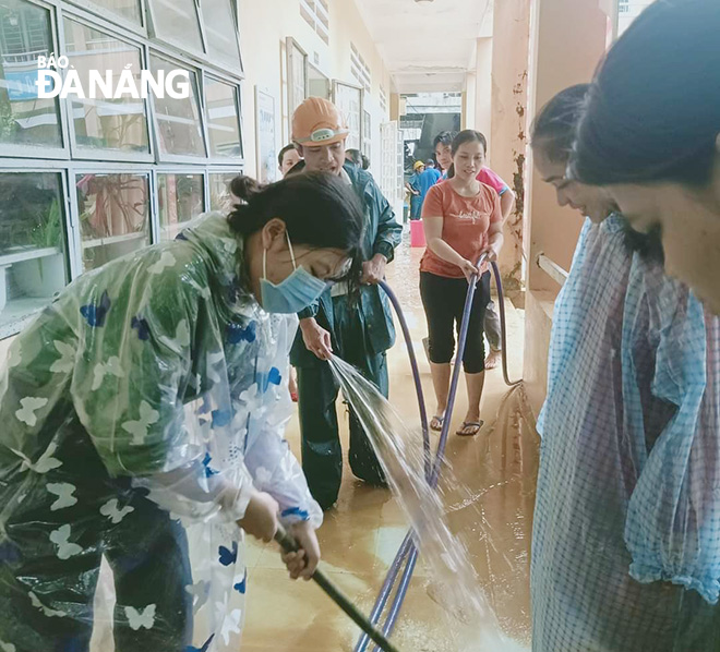 Teachers of the Hoa Bac Primary School in Hoa Vang District cleaning up mud on the ground