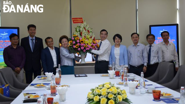 Phó Chủ tịch UBND thành phố Lê Trung Chinh (thứ 5 từ phải sang) tặng hoa, chúc mừng đại diện Công ty TNHH Sân gôn VinaCapital. Ảnh: THU HÀ