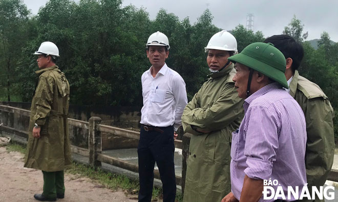 Phó Chủ tịch UBND thành phố Hồ Kỳ Minh (thứ 3, trái sang) trực tiếp chỉ đạo đóng cửa tràn hồ Đồng Nghệ và tìm kiếm người mất tích tại hiện trường. Ảnh: HOÀNG HIỆP
