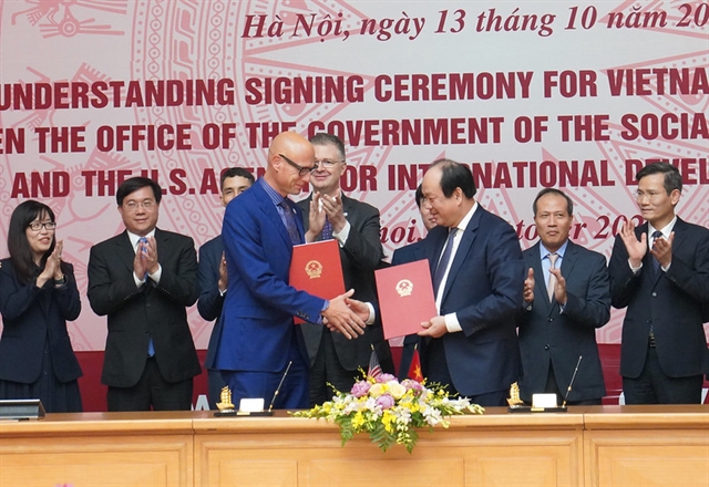 United States Agency for International Development (USAID) Acting Việt Nam Mission Director Bradley Bessire (left) and Việt Nam's Office of the Government (OOG) Chairman Mai Tiến Dũng exchanged Memorandum of Understanding on the development of a strategic framework agreement for the Việt Nam E-Government Capacity Building programme in a ceremony held Tuesday in Hà Nội. — Photo courtesy of the US Embassy in Việt Nam