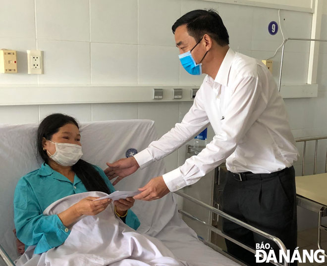 Phó Chủ tịch UBND thành phố Lê Trung Chinh ân cần thăm hỏi nạn nhân. 			              Ảnh: NGỌC ĐOAN
