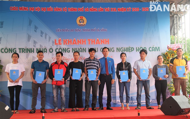 Chủ tịch Liên đoàn Lao động thành phố Nguyễn Duy Minh (thứ 5, phải sang) trao quyết định thuê nhà đợt 1 cho 18 công nhân lao động. Ảnh: L.P