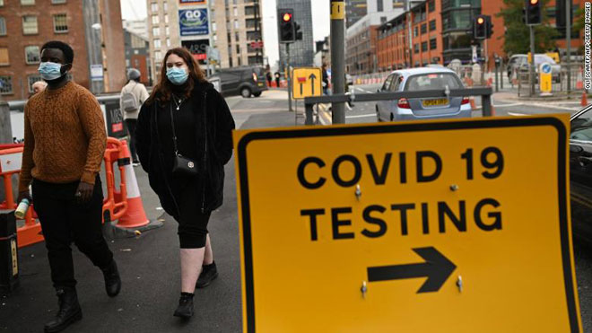 Các thành phố ở Anh, Pháp, Tây Ban Nha thắt chặt quy định kiểm soát dịch.  Trong ảnh: Người dân mang khẩu trang khi đi trên đường phố Manchester (Anh). Ảnh: AFP/Getty Images